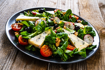 Fresh salad - blue cheese and vegetables on wooden table