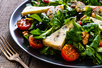 Fresh salad - blue cheese and vegetables on wooden table