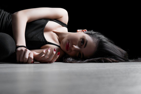 Portrait of young woman lying down on a floor