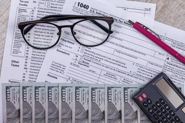 Income tax with instruction, money, calculator and glasses. Tax payment and filing concept