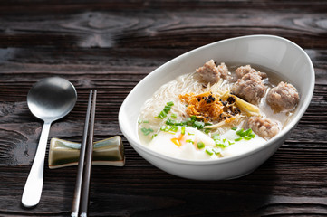 Thai style clear soup rice noodle in traditional bowl. Selective focus