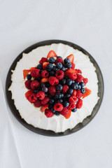 Tasty summer berry baiser pavlova cake with strawberries, raspberries and blueberries