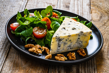 Fresh salad - blue cheese and vegetables on wooden table