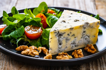 Fresh salad - blue cheese and vegetables on wooden table