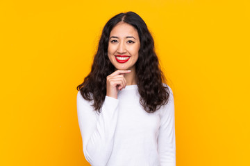 Mixed race woman over isolated yellow background laughing