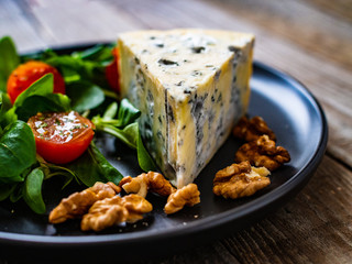 Fresh salad - blue cheese and vegetables on wooden table