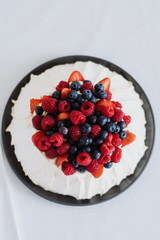 Tasty summer berry baiser pavlova cake with strawberries, raspberries and blueberries