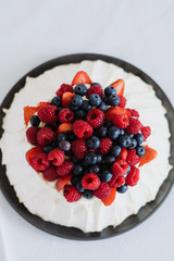 Tasty summer berry baiser pavlova cake with strawberries, raspberries and blueberries