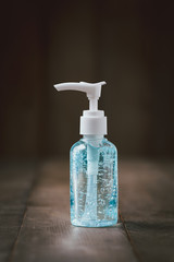Hand sanitizer bottle or alcohol gel on old wood background