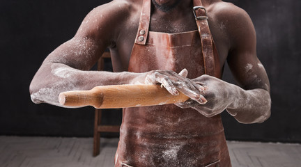 Dark skin baker man kneads Dough in the kitchen. Pastry chef prepares yeast dough for pizza pasta.