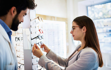 Young woman in optic store choosing a new glasses. Medical, health care concept