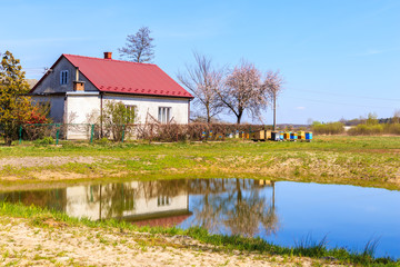 Naklejka na ściany i meble Typical house with beehives and small pond in rural area near Puszcza Niepolomicka near Krakow city, Poland