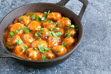 Meatballs in sweet and sour tomato sauce with spices.