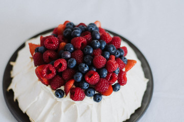 Tasty summer berry baiser pavlova cake with strawberries, raspberries and blueberries