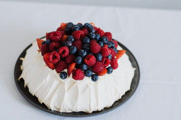 Tasty summer berry baiser pavlova cake with strawberries, raspberries and blueberries