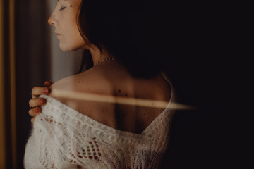 Portrait d'une jeune femme &agrave; travers la fen&ecirc;tre