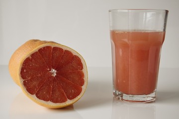 a glass of fresh pink grapefruit juice on a white backgroud