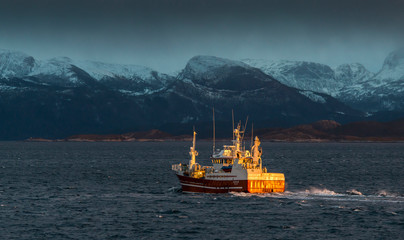 Arctic Trawler catching the Sunset heading along a Norwegian Fjord