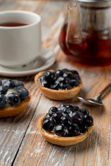 Close up of rustic homemade tartlets with custard and blueberry