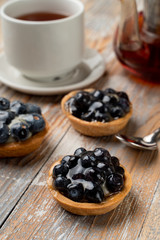 Close up of rustic homemade tartlets with custard and blueberry