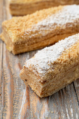 Napoleon with custard and puff dough, traditional russian treat, cut and served on wooden vintage table