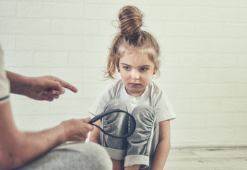 A man threatens a child with a belt