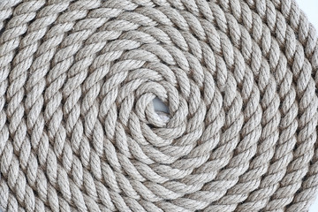 Braided thick rope tied in a skein. Hemp rope for decoration and design. Background from a fishing rope.