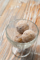 Cake-pops made of sponge cake, coconut and chocolate in a glass bowl