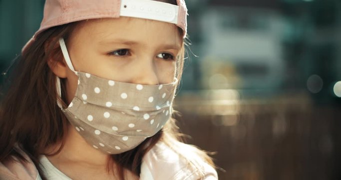 Dziewczynka w maseczce chirurgicznej na ulicy - portret.