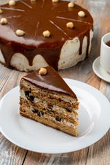 A mouthwatering slice of hazelnut meadow torte with caramel and a cup of black tea