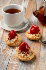 Small tartlet with cream and a whole strawberry, glazed and golden for decoration