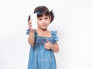 Little Asian cute girl 4 years old holding and drinking milk from carton of milk and trumps up on white background. Milks is essential and nutrition for the child's body.