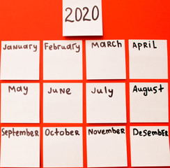 calendar months from paper stickers on a red background. view from above