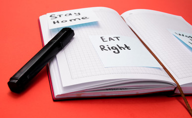 the notebook in the open position lies on the table, the inscription on the stickers "stay home. work at home"