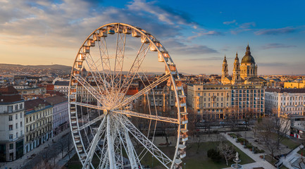 Budapest, Hungary - Aerial panoramic view of the ferris wheel at Elisabeth Square (Erzsebet ter) at sunset with St. Stephen's Basilica, Parliament building and blue sky and clouds at background