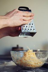 Man cooking with hard cheese, , hand with cheese grater