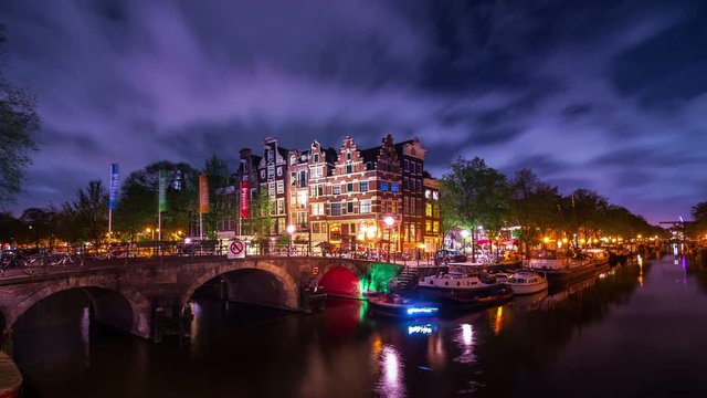 Amsterdam amazing timelapse of the corner of 'Prinsengracht' and 'Brouwersgracht' canals after sunset and blue hour at night in summer. With fast moving clouds and stars. UNESCO World Heritage list