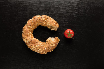 Turkish bagel on white background with tomato (simit)