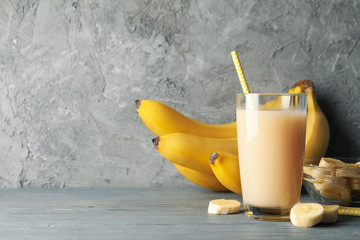 Bananas and juice against gray background. Fresh fruit