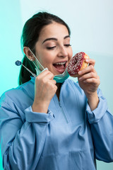 Dentista , indecisa tra mangiare u dolce o la cura dei denti, isolata su sfondo chiaro