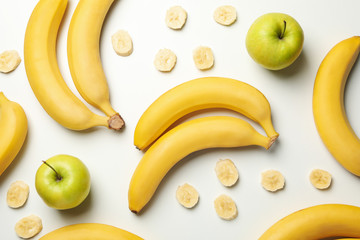 Bananas and apples on white background, top view. Fresh fruit