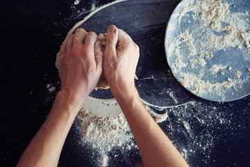 Unrecognizable male cook. A male baker is cooking bread. Making bread.
