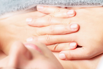 Chest massage of woman by hands of massage therapist, close up.
