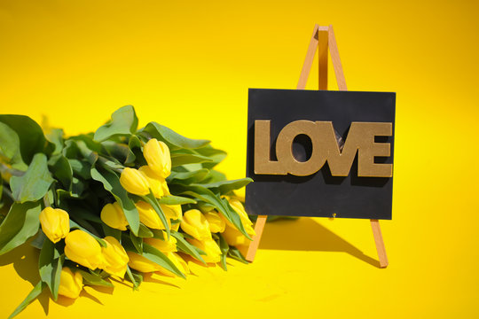 yellow tulips with love on blackboard