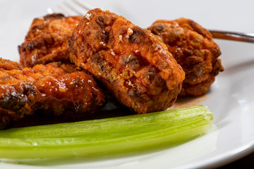 Plate of boneless buffalo chicken wings with a side of celery