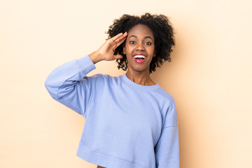 Young African American woman isolated on beige background has realized something and intending the solution