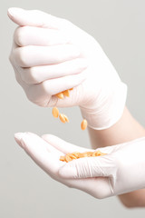 Hard wax beans in hands of cosmetologist, close up.