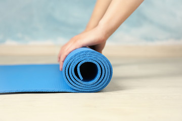 Woman lays out a fitness mat. Healthy lifestyle