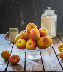 Set for making apple pie. Fresh apples in a glass vase, flour in a glass jar and icing sugar in a high glass jar