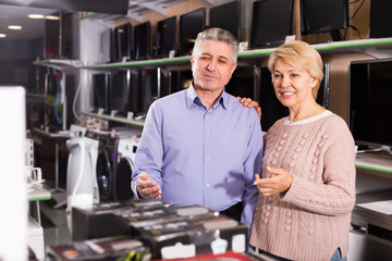 Fototapeta na wymiar Husband and wife in home appliance shop to discuss item